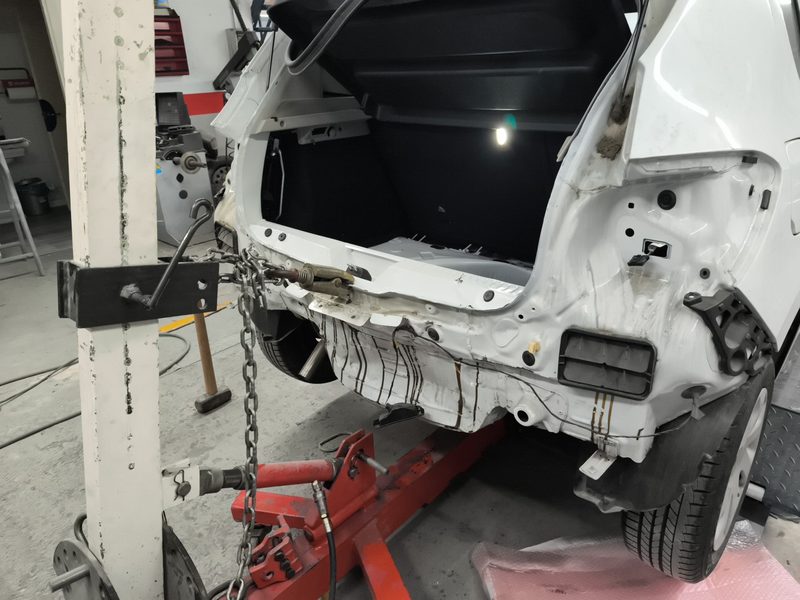 Part posterior d’un cotxe blanc fixada a la bancada amb la unitat de tir